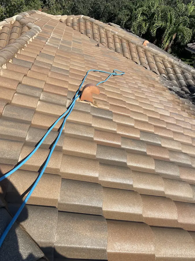 Barrel tile roof with a soft-wash hose run up the ridge