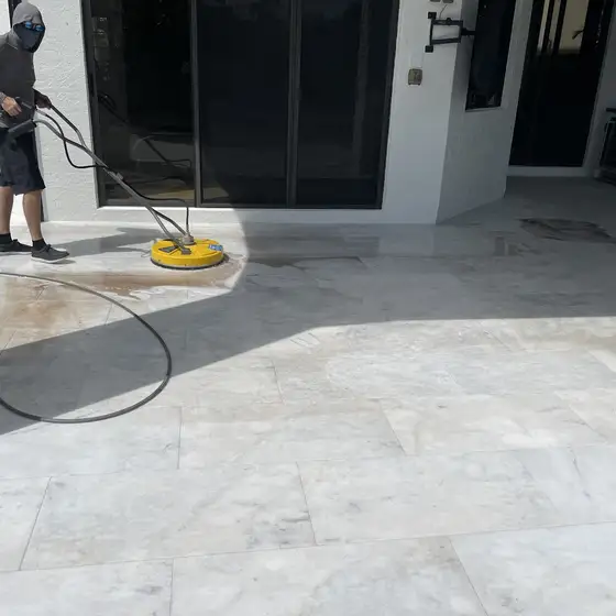 Surface cleaner working across a white tile patio