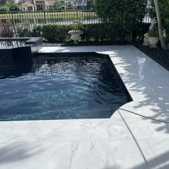White deck around a dark-bottom pool